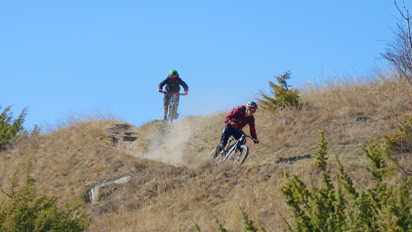 Rider de descenso en una loma de montana