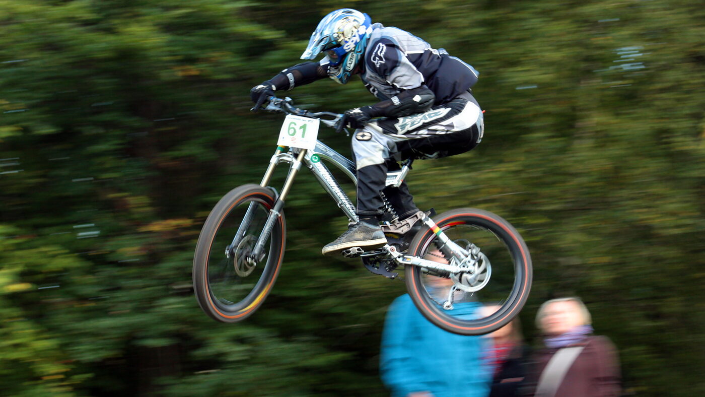 Rider saltando un kicker de madera en un bikepark